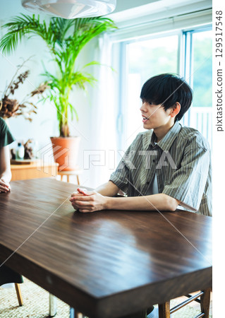 客廳裡，一位男士在木桌旁休息 129517548