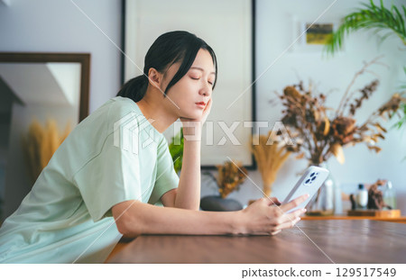 一位女士在智慧型手機上研究某件事的嚴肅表情 一位女士在智慧型手機上研究某件事的嚴肅表情 129517549