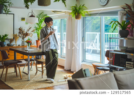 A simple interior with a wooden table, cups and books 129517565