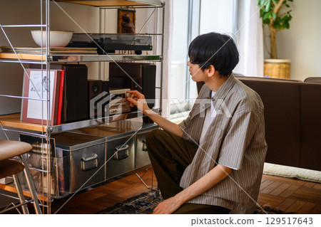 A man operating a music device in his living room on a holiday 129517643