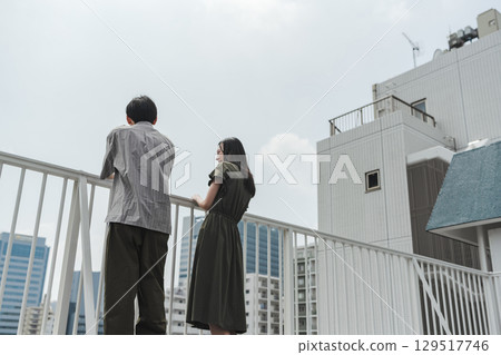 Men and women thinking about the future over the railing on the rooftop Men and women thinking about the future over the railing on the rooftop 129517746