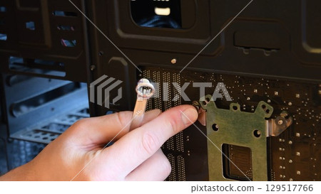 Male hand with metal wrench fix nut on bolt at computer motherboard Male hand with metal wrench fix nut on bolt at computer motherboard 129517766