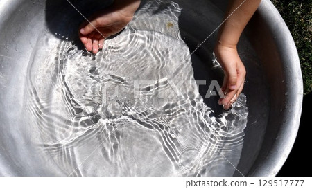 Toddler hands trying to collect clear water in handful playing water games Toddler hands trying to collect clear water in handful playing water games 129517777
