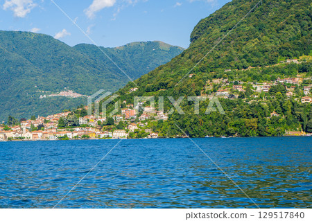 Multicolor houses building architecture on lake Como, Italy city. Green mountain hill 129517840