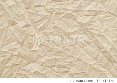 Old textile, crumpled texture, surface for background. Pale brown recycled battered kraft material, copy space for text 129518170