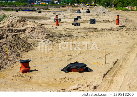 Utility Access Points and Manholes on Sandy Construction Site for Infrastructure Development Utility Access Points and Manholes on Sandy Construction Site for Infrastructure Development 129518200