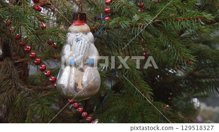Vintage Christmas ornament hanging on conifer tree branch Vintage Christmas ornament hanging on conifer tree branch 129518327