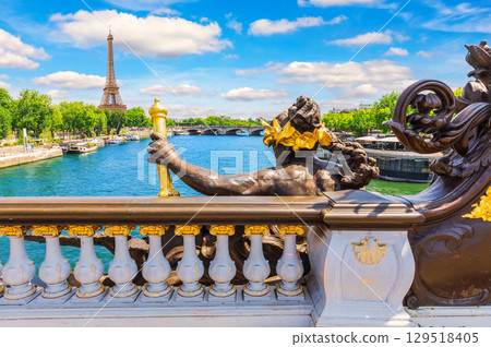 Close-up of bronze sculpture on Paris s Alexander III Bridge with panorama behind Close-up of bronze sculpture on Paris s Alexander III Bridge with panorama behind 129518405