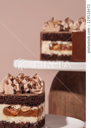 Caramel and nut bento cake with chocolate sponge layers, topped with creamy frosting, presented on a white plate, showcasing a delightful dessert concept for pastry enthusiasts Caramel and nut bento cake with chocolate sponge layers, topped with creamy frosting, presented on a white plate, showcasing a delightful dessert concept for pastry enthusiasts 129518472
