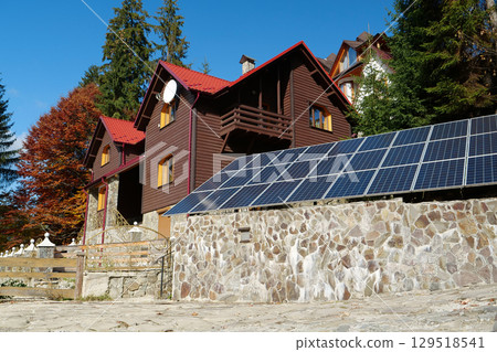 Independent source of green energy. Solar cell panels near country cottage Independent source of green energy. Solar cell panels near country cottage 129518541