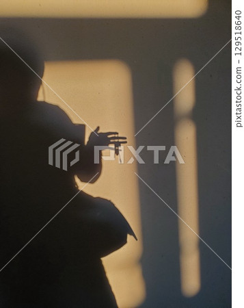 Defocus shadowy silhouette holding bunch of keys in hand Defocus shadowy silhouette holding bunch of keys in hand 129518640