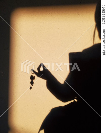 Elegant gesture of female hand with keys, shadow on wall Elegant gesture of female hand with keys, shadow on wall 129518643