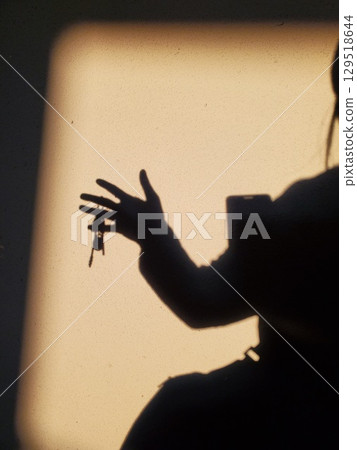 Female shadowy silhouette with keys in hand Female shadowy silhouette with keys in hand 129518644