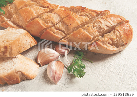 garlic bread,baguette with garlic butter and herbs, on a light table, top view, garlic bread,baguette with garlic butter and herbs, on a light table, top view, 129518659