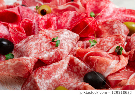 Assorted, meat appetizer, prosciutto, salami and ham, with olives , close-up, breakfast, top view, close-up, without people 129518683