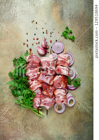 raw pork meat, on wooden skewers, pickled kebab , with spices and herbs, on the table, top view, no people, raw pork meat, on wooden skewers, pickled kebab , with spices and herbs, on the table, top view, no people, 129518694