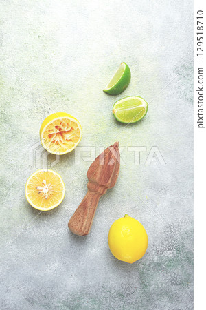 Wooden citrus reamer, manual lemon juicer, made of acacia wood, with citrus fruits on the table, top view, 129518710