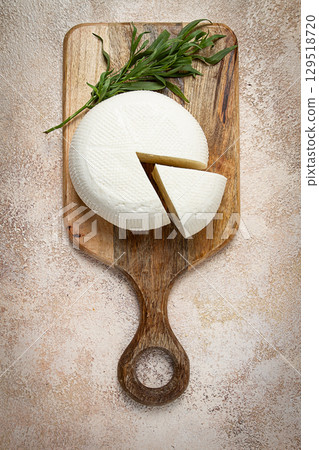 Head of Georgian cheese, Imereti variety, top view, on a cutting board, Head of Georgian cheese, Imereti variety, top view, on a cutting board, 129518720