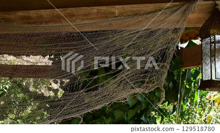 Old torn net and vintage lantern in haunted house. Halloween decor Old torn net and vintage lantern in haunted house. Halloween decor 129518780