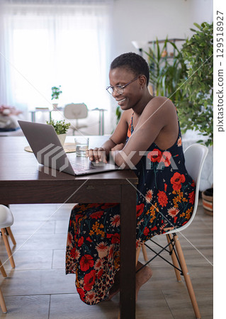 Young woman using her laptop, working from home 129518927