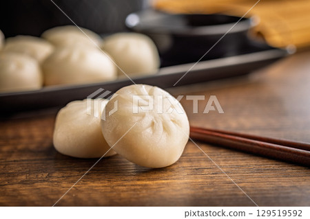 Xiao long bao. Chinese dumplings on wooden table. 129519592