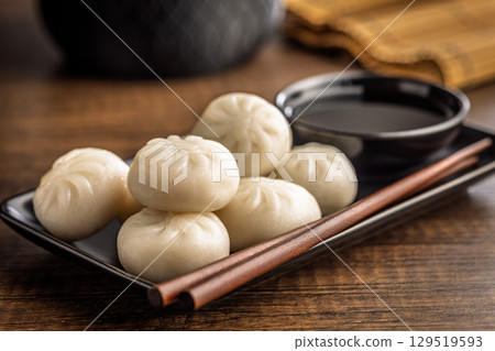 Xiao long bao. Chinese dumplings and soy sauce on wooden table. Xiao long bao. Chinese dumplings and soy sauce on wooden table. 129519593