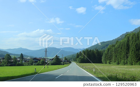 Scenic austrian Road Leading to Alpine Mountain Village with Forest View Scenic austrian Road Leading to Alpine Mountain Village with Forest View 129520963