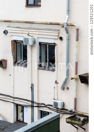 Air conditioners are installed on facade of building. device for comfortable living in hot weather. 129521201
