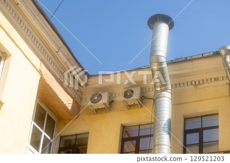 Air conditioners are installed on facade of building. device for comfortable living in hot weather. 129521203