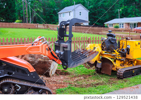 Heavy machinery used for land clearing yard maintenance in suburban area on works day 129521438