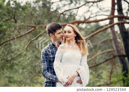 Cute couple in a park. Lady in a white dress. Guy in a blue shirt 129521584