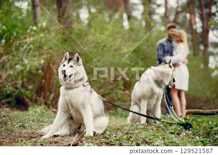 Couple in a forest. Pair with cute dogs. Lady in a white dress 129521587