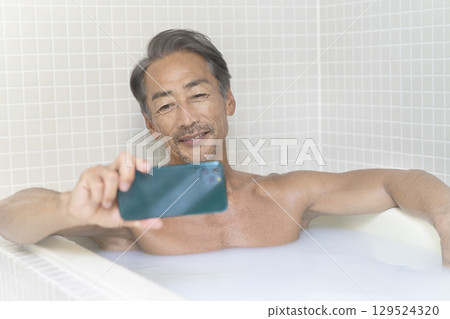 老人洗澡時看著智慧型手機 129524320
