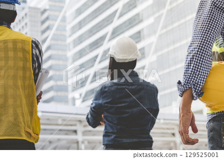 Helmet construction Engineer team. Men hands holding hardhat yellow work helmet in Civil Construction Engineering. Close up engineer man hold safety yellow worker helmet hard hat at Construction Site Helmet construction Engineer team. Men hands holding hardhat yellow work helmet in Civil Construction Engineering. Close up engineer man hold safety yellow worker helmet hard hat at Construction Site 129525001