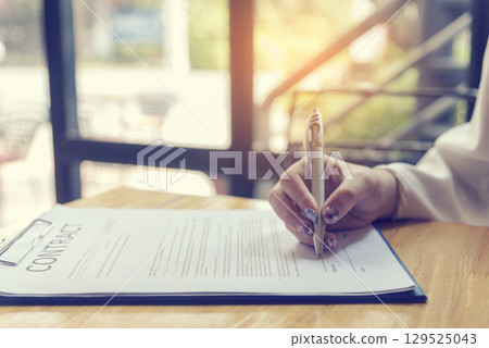 Businesswoman hands note meeting document in conference room. Woman Hands writing planning on notebook. Female hand holding pencil write on diary sketchbook. Business Planning Concept. 129525043