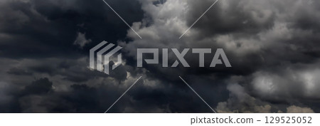 Banner Dramatic dark storm clouds black sky background. Dark thunderstorm clouds rainny season. Panorama Meteorology danger windstorm disasters climate. Dark cloudscape storm cloud with copy space. Banner Dramatic dark storm clouds black sky background. Dark thunderstorm clouds rainny season. Panorama Meteorology danger windstorm disasters climate. Dark cloudscape storm cloud with copy space. 129525052