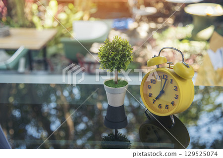 Alarm clock Red vintage retro time on book and tree green nature bokeh nature deadline concept. 129525074