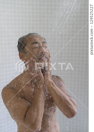 一位 60 歲左右的男子正在洗澡 129525227