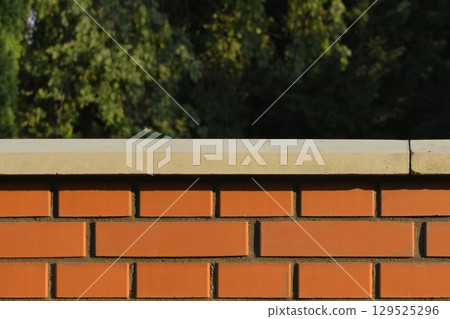 View of the brick base. Brick wall with white finished top with polished white capstone. Brick base. Brick background with polished headstone. Building and construction concept. View of the brick base. Brick wall with white finished top with polished white capstone. Brick base. Brick background with polished headstone. Building and construction concept. 129525296