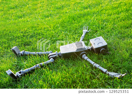 Happy humanoid robot lies on the autumn grass. Happy humanoid robot lies on the autumn grass. 129525351