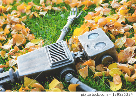 Happy humanoid robot lies on the autumn grass. Happy humanoid robot lies on the autumn grass. 129525354