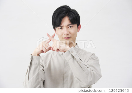 Male, 20s, making a cross gesture with his fingers, white background 129525643