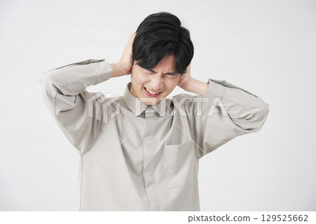 Man covering his ears, 20s, white background Man covering his ears, 20s, white background 129525662