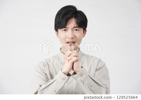 一名 20 多歲、白色背景、正在懇求的男人看著相機 129525664