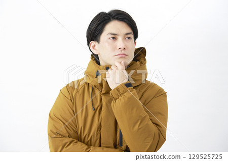 一位身穿羽絨外套的男子在白色背景上思考 129525725