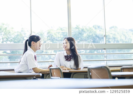 高中女生在教室裡和朋友聊天 高中女生在教室裡和朋友聊天 129525859