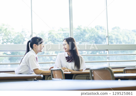 高中女生在教室裡和朋友聊天 129525861