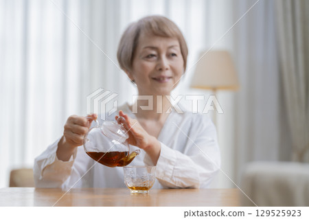 餐廳裡倒茶的老年婦女 餐廳裡倒茶的老年婦女 129525923