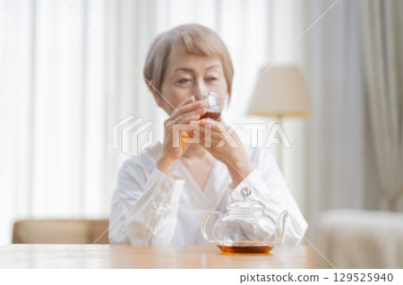 餐廳裡倒茶的老年婦女 129525940