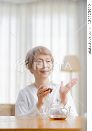 餐廳裡倒茶的老年婦女 129525949